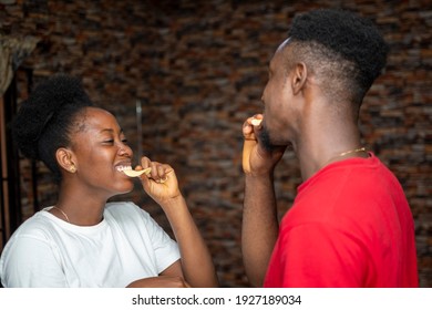 Young African Man And Woman Enjoying Eating Chips