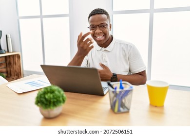 Young African Man Working At The Office Using Computer Laptop Beckoning Come Here Gesture With Hand Inviting Welcoming Happy And Smiling 