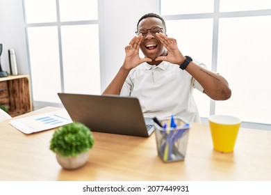 Young African Man Working At The Office Using Computer Laptop Smiling Cheerful Playing Peek A Boo With Hands Showing Face. Surprised And Exited 