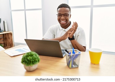 Young African Man Working At The Office Using Computer Laptop Clapping And Applauding Happy And Joyful, Smiling Proud Hands Together 