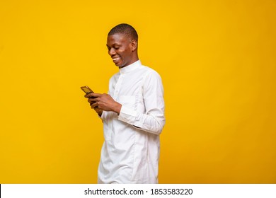 Young African Muslim Man Smiling While Using His Phone