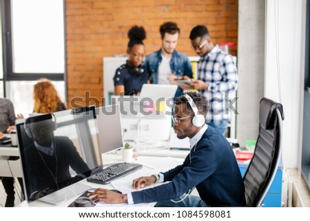 young African programmer working on personal computer in the call center