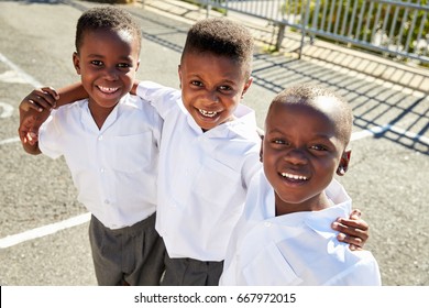 Young African Schoolboys Smiling To Camera In A Playground