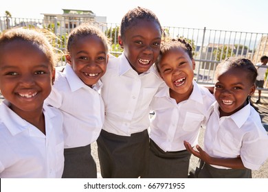 Young African Schoolgirls In Playground Smiling To Camera