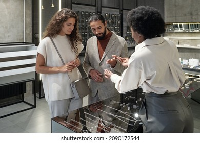 Young African Shop Assistant Helping Clients With Choosing New Necklace For Woman In Jewelry Boutique