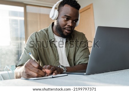 Young african student using computer laptop while studying inside library cafe - Focus on face