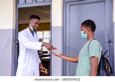 A Young African Teacher Gave His Student Hand Sanitizer To Wash Her Hand.