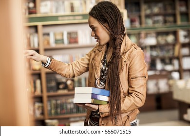 Young African Woman Buying Books At A Bookstore.