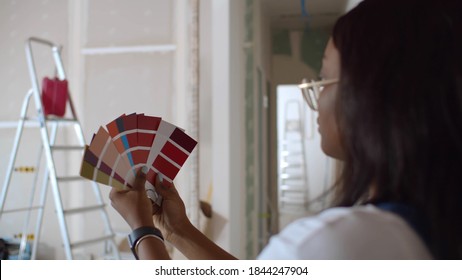 Young African Woman Choosing Paint Color From Swatch For New Interior Design. Afro Female Holding Palett With Colors Choosing Paint For Wall Decoration