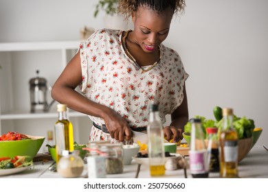 Young African Woman Cooking. Healthy Food - Vegetable Salad. Diet. Dieting Concept. Healthy Lifestyle. Cooking At Home. Prepare Food