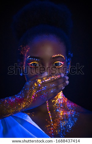 young african woman forced to keep silence, incognito close her moutgh. creative prints glows on neon lights. body art, silence concept