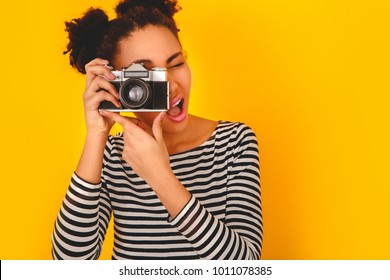 Young african woman isolated on yellow wall studio teen style taking pictures close-up