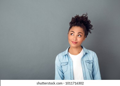Young african woman isolated on grey wall studio casual daily lifestyle thinking close-up - Shutterstock ID 1011716302