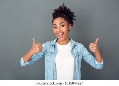 Young african woman isolated on grey wall studio casual daily lifestyle thumbs up