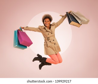 Young African woman jumping with shopping bags in her hands.