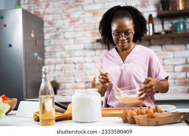 Young African woman in kitchen. Beautiful woman having fun while making dough.	 - Powered by Shutterstock