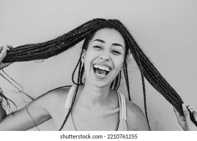 Young African Woman Laughing On Camera While Holding Pigtail Hair