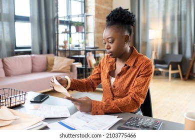 Young African Woman Sitting By Table And Putting Filled Form Into Envelope Before Sending It To Organization