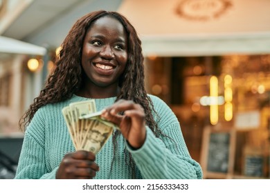 Young African Woman Smiling Happy Holding Dollars Banknotes At The City