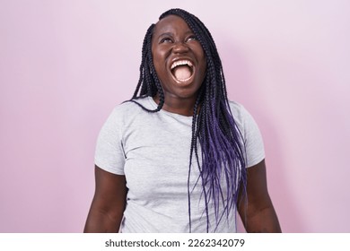 Young african woman standing over pink background angry and screaming frustrated and furious, shouting with anger. rage and aggressive concept.  - Shutterstock ID 2262342079