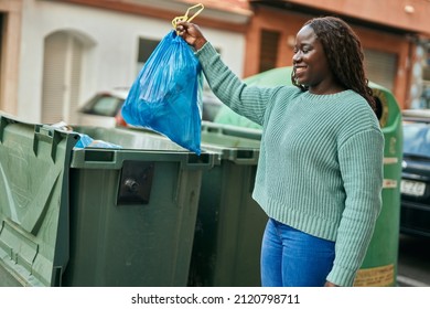 Young African Woman Throwing Out The Trash At The City