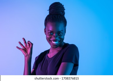 Young African Woman Win Okay Sign On Neon Background