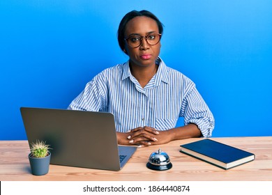 Young African Woman Working At Hotel Reception Using Laptop Depressed And Worry For Distress, Crying Angry And Afraid. Sad Expression. 