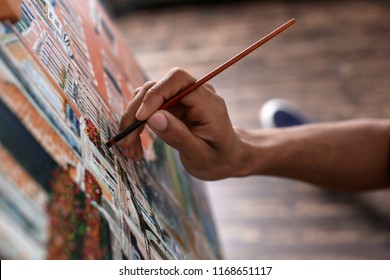 Young African-American artist painting picture in workshop, closeup - Powered by Shutterstock