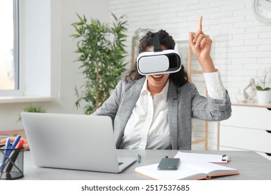 Young African-American businesswoman in VR glasses at table in office - Powered by Shutterstock