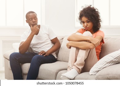 Young african-american couple quarreling at home, woman offended. Family relationship difficulties concept, copy space
