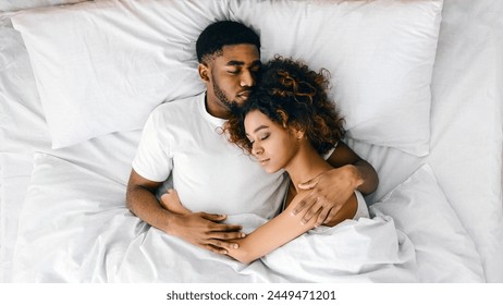 Young african-american couple sleeping together in bed, top view, copy space - Powered by Shutterstock