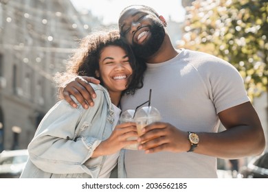 Young african-american couple spouses hugging embracing together while drinking lemonade on a date walking outdoors in city. Love and relationship concept - Powered by Shutterstock