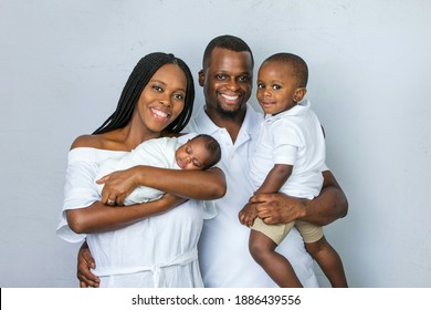 A young African-American family in the studio with two sons, one who is a toddler and one who is a newborn boy