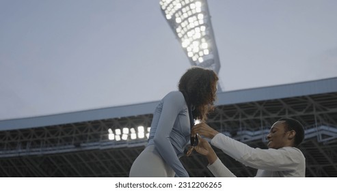 Young African-American Female Athlete Celebrates a Win on a podium, receives a gold medal - Shutterstock ID 2312206265