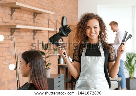 Young African-American hairdresser in beauty salon