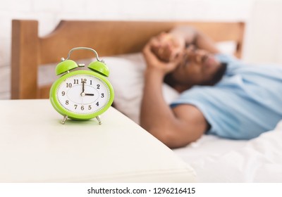 Young african-american man in bed suffering from insomnia and sleep disorder, thinking about his problems at night, copy space