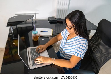 Young African-American Student Studying At A Distance Using Online Continuing Education Courses And Sitting At A Table With Appliances And Notebook And Freshly Squeezed Juice