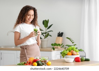 Young African-American woman drinking healthy smoothie in kitchen - Shutterstock ID 2224640709