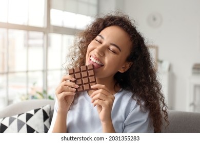 Young African-American Woman Eating Chocolate At Home