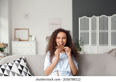 Young African-American Woman Eating Chocolate At Home