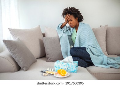 Young African-American Woman Feeling Sick At Home. Lying In Bed, Drinking Tea And Medicine. Adult African American Woman Staying At Home Feeling Sick, Having A Sore Throat And Drinking A Cup Of Tea