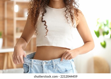 Young African-American Woman In Loose Clothes At Home. Diet Concept