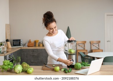 Young African-American woman making smoothie in kitchen - Powered by Shutterstock