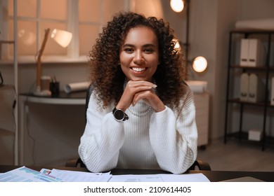 Young African-American Woman Sitting In Office At Night