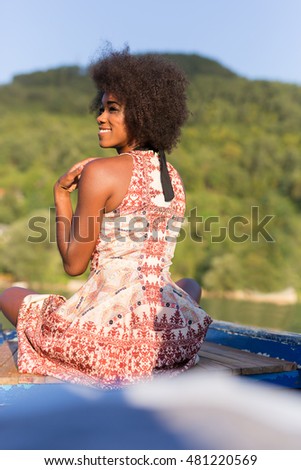 young afro american tanned woman in bikini on old fishing boat posing  and smiling