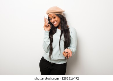 Young afro american woman on white wall happy and counting two with fingers