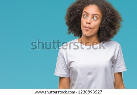 Young afro american woman over isolated background making fish face with lips, crazy and comical gesture. Funny expression.