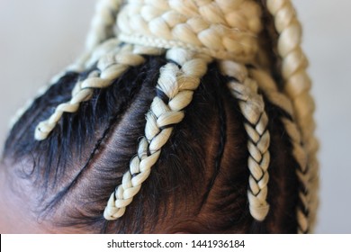 Young afro with blonde Box braids, African hair style also known as "Kanekalon braids." Close up on decoration and style.