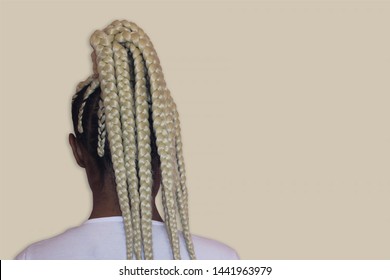 Young afro with blonde Box braids, African hair style also known as "Kanekalon braids." Close up on decoration and style. Copy Space.
