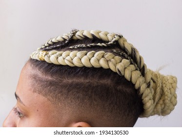 Young afro with blonde Box braids, African hair style also known as "Kanekalon braids." Close up on decoration and style.